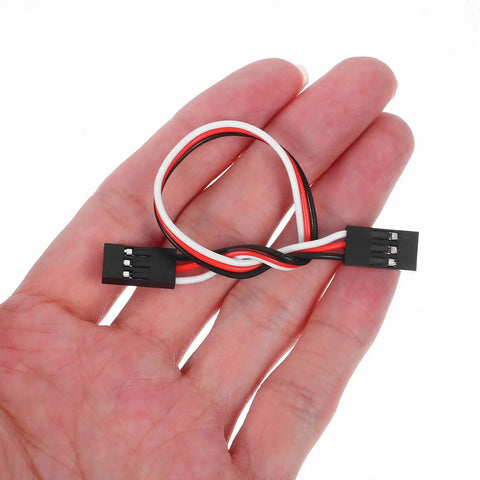 Hand holding 15cm 3 Pin Female To Female RC Extension Cable from 10 Pack for RC Airplane Car Helicopter Boat Receiver and Controller