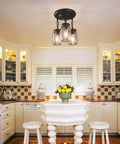 Industrial 3 Light Pendant With Slick Matte Black Finish Clear Glass Mason Jar Shade above kitchen island with white stools.