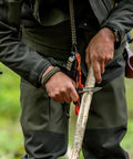 Close-up of hands using 5 In 1 Paracord Survival Bracelet With Compass Fire Starter Whistle Glass Breaker and Paracord outdoors