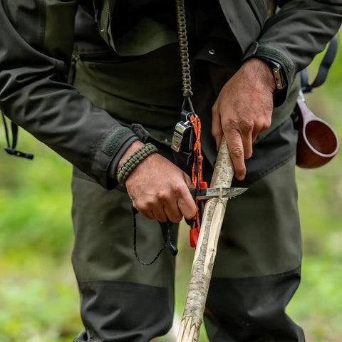 Close-up of hands using 5 In 1 Paracord Survival Bracelet With Compass Fire Starter Whistle Glass Breaker and Paracord outdoors