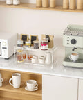 2 Tier Coffee Station Organizer for Countertops Acrylic Storage Shelf to Hold Mugs Beans Syrup Cups and Stirrers Neatly Stacked Barista Style Coffee Bar Setup Maximizes Counter Space and Rids Clutter