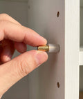 Installing brass shelf support pins for cabinets and bookcases, 12 metal pegs with rubber covers for tool-free installation