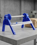 Plastic Wrap Dispenser With Cutter For Tabletop Use, blue manual packaging tool on table with box, ideal for cling wrap.