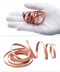 Gloved hand holding Desoldering Pro Grade Solder Wick Braid Red Copper for quick tin removal, coiled pieces below.