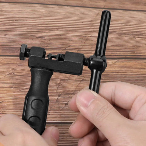 Universal Bike Chain Breaker Tool And Cutter For 7 8 9 10 11 Speed Chains With Spare Replaceable Pin in hand on wooden surface