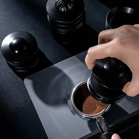 Straight Up Pro Grade 58Mm Espresso Accessories Kit with black aluminum tamper pressing coffee grounds in a portafilter.