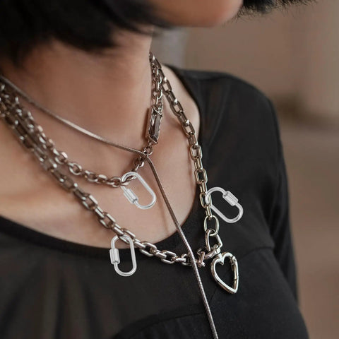 Model wearing silver chain necklace with Ten Pack Screw Carabiner Lock Charms For DIY Jewelry Making Gold Tone Small Locking Carabiners.