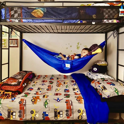 Kid Friendly Camping Hammock For Indoors And Outdoors in a child's bedroom near bunk bed, blue color with toys inside.