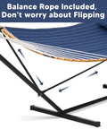 Portable Outdoor Hammock With Stand And Carrying Bag Heavy Duty Camping Hammock With Soft Pillow Stable Balance Ropes Durable Two Layer Quilted Polyester Non Fading Comfort Dark Blue For Chill Sessions Outdoors with black metal stand and blue quilted fabric, side view showing stable ropes.