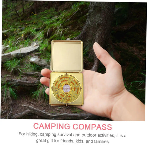 Hand holding Small 10cm Alloy Feng Shui Compass With Flip Cover, Waterproof Outdoor Navigation Tool for Camping, in forest setting