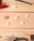 50 Piece Metal And Plastic 45 Degree Triangle Shelf Brackets for kitchen cabinets on wooden surface with tools
