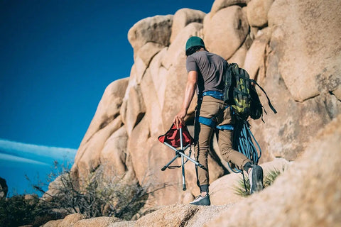 Hiker carrying Slacker Tripod Camping Chair For Hiking And Fishing, Ultra Lightweight Foldable Seat With Adjustable Carry Strap