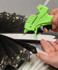 Person using Cool Shot Ultra Low Temp 4 Inch Mini Glue Sticks Pack For Delicate Materials Like Balloons Ribbon Lace Fabric And Foam Crafts DIY Friendly 15 Count Ideal For Low Temp Glue Guns with green glue gun on black paper decoration
