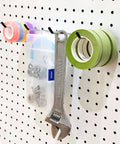 4 Inch Pegboard Hooks 25 Pack Pegboard Organizer Kit For Garage Storage And Tool Workshop Organization, Heavy Duty L Shape Hooks With 20lb Capacity Fits Standard Pegboards At Home Or Shop holding tools and tape rolls on a pegboard