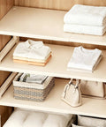 Adjustable Closet Shelf Organizer With Expandable Storage Rack For Pantries And Closets showcasing neatly stacked clothes and towels.