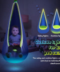 Child sitting in Light Up Kids Pod Swing Chair with LED Lights, illuminated blue and green, room background with toys.