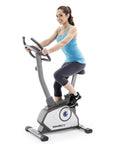 Person exercising on Magnetic Upright Bike With 8 Resistance Levels NS-40504U Grey, cushioned adjustable seat, home gym use.