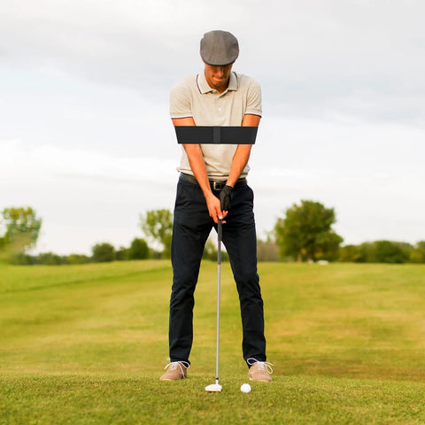 Man practicing golf on course with Golf Swing Trainer Aid With Grip Trainer Attachment And Arm Band For Swing Correction Game Changing Tool