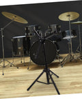 Heavy Duty Tripod Drum Stand And Snare Rack Holder Featuring Non Slip Base For Rock Solid Practice Routines In Sleek Black Finish, positioned in front of drum kit.
