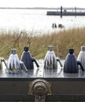 Polished solid brass and other shower heads with Anystream technology on a trunk by a waterfront