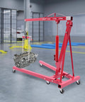 Heavy Duty Two Ton Hydraulic Engine Hoist With Smart Leveler And Folding Cherry Picker Shop Crane Lift Built Like A Tank supporting an engine.