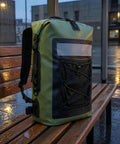 Waterproof Roll-Top Backpack With Padded Straps 35L Daypack For Hiking And Camping on a rainy bench, green and black design.