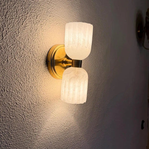 GLEAMING NEST Modern Alabaster Wall Sconce, Double Light Fixture, Antique Brass Finish, Fluted Stone Shades, Contemporary Wall Lamp viewed from the side.
