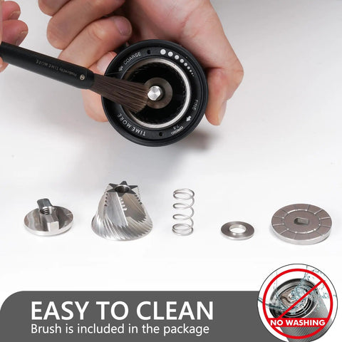 Disassembled view of Chestnut C3S Manual Coffee Grinder With All Metal Aluminum Body Conical Burr showing cleaning with a brush