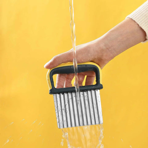 Front view of a two-piece stainless steel crinkle cutter with yellow and black handle being washed under running water