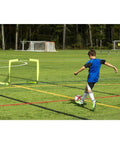 Child playing soccer with Portable Backyard Soccer Goal Small Size Pop Up With Quick Setup Durable Fiberglass Frame All Weather Practice Net For Training And Small Sided Kickaround Games With Friends Perfect For Driveway Or Lawn on the field.