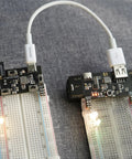 Breadboard Power Supply Module With USB Type C Port And DC 2.1mm Input 3.3V And 5.5V Adjustable Output 0.15A To 2A Simple Plug And Play Charging Kit For Breadboard Electronics Experiments installed on breadboards, showing USB-C connection and lit LEDs.