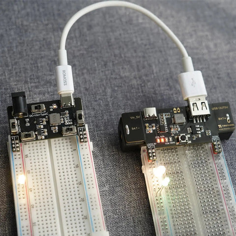 Breadboard Power Supply Module With USB Type C Port And DC 2.1mm Input 3.3V And 5.5V Adjustable Output 0.15A To 2A Simple Plug And Play Charging Kit For Breadboard Electronics Experiments installed on breadboards, showing USB-C connection and lit LEDs.