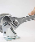 Hand using 15 Inch Adjustable Wrench With 45mm Jaw Opening For Heavy Duty Garage And DIY Projects on a large caster wheel