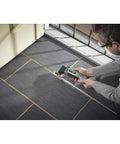 User cutting gray flooring with Reconditioned Corded Oscillating Multi Tool Kit Featuring Durable Metal Frame Engineered For Sharp Cutting Sanding Scraping And Grinding Plug And Play Workhorse Built Like A Dang Tank To Finish Jobs Fast