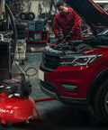 Mechanic using Oil Free 6 Gallon Pancake Air Compressor, 175 PSI Portable Little Powerhouse in auto workshop