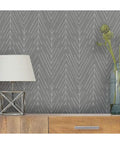Charcoal Gray Twig Hygge Herringbone Peel And Stick Wallpaper 20.5 Inches Wide 16.5 Feet Long on wall with lamp and decor