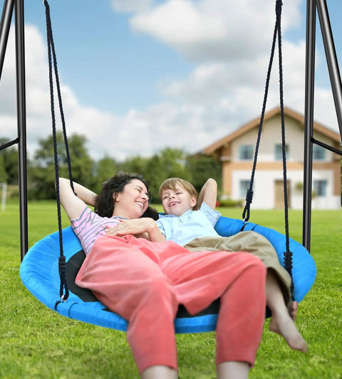 Heavy Duty Saucer Swing With Frame For Backyard Fun And Safe Outdoor Play 440 Pound Capacity Sturdy Frame Stand Powder Coated Steel Ground Anchors Kids Playground Equipment For All Weather Family Fun featuring a mother and child relaxing outdoors