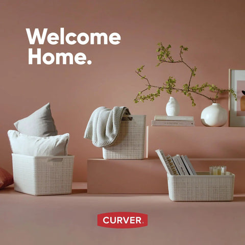 Three white woven-style storage baskets with home decor on a pastel background