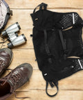 Go To Hydration Backpack for Running Cycling and Hiking with Quick Access Water Bladder on wooden floor with hiking boots
