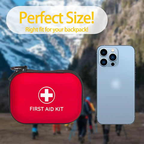 Red zippered first aid kit pouch with white cross; smartphone for scale in outdoor hiking scene.