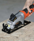 Front view of Yunirvana 4Amp mini circular saw with laser guide; orange body, gray housing, on wood work surface