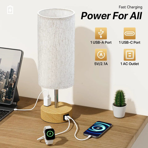 Bedside Lamp With USB A And C Ports And AC Outlet, 3 Way Dimmable Touch Lamp, Linen Fabric Shade, charging devices on desk.