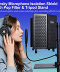 Pro Grade Microphone Isolation Shield With Pop Filter And Tripod Stand next to person wearing headphones