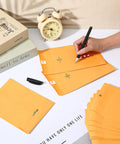 Person writing on 200 Pack 5 By 7 Inch Clasp Manila Envelopes With Gummed Closure 28 Lb Paper Yellow Office Mailer Envelopes for Home and Biz Use