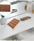Slick Multi Grid Jewelry Tray Wooden Desktop Organizer Phone Stand For Rings Earrings And Bracelets on a vanity, holding jewelry.
