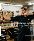 Person demonstrating 33 Inch Handmade Wooden Archery Arrows Set with Turkey Feather Fletching in workshop setting