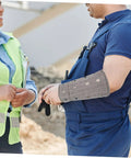 Man wearing Heavy Duty Cut Resistant Wrist Sleeves For Men And Women Beefy Arm Guards during a work discussion.
