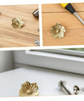 Vintage Brass Flower Cabinet Handle Single Hole Drawer Pull For Wardrobe And Cupboard Doors displayed with screws on wood.