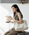 Woman holding On The Go Grab And Go Portable Electric Kettle 24oz Mini Travel Kettle For Camping And Office, beige color.