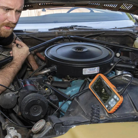 Mechanic using WiFi Pro Borescope With Dual Lens 5.5 mm 9.8 Foot Armored Waterproof Gooseneck Endoscope to inspect car engine